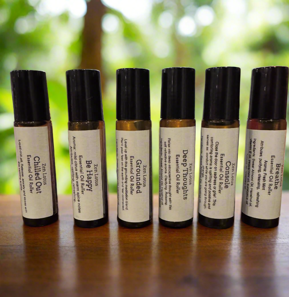 Set of six essential oil roller bottles with labels on a wooden surface.